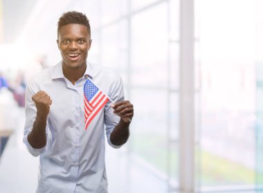 Duygu tezahürat gurur çığlık ve zafer ve başarı çok heyecanlı, kutluyor ABD bayrağı tutan genç Afro-Amerikan adam