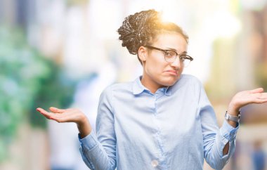 Genç saç Afro-Amerikan iş kız gözlüklü izole arka plan clueless ve şaşkın bir ifadeyle kollar ve eller kaldırdı üzerine örgülü. Şüphe kavramı.