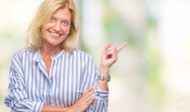 Kameraya bakarak yan el ve parmak ile işaret orta yaş sarışın iş kadını yüzünde kocaman bir gülümseme ile izole arka plan üzerinde.