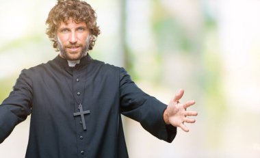 Sarılmak için kollarını açarak gülümseyerek kameraya bakarak izole arka plan yakışıklı İspanyol Katolik rahip adam. Neşeli ifade kucaklayan mutluluk.