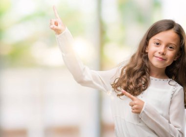 Gülümseyen ve iki ile işaret kamera bakarak esmer Latin kız eller ve yan parmak.