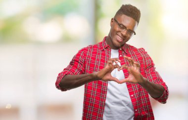 Afrikalı-Amerikalı genç aşık kalp simgesi ve elleriyle şekil gösteren gülümseyen izole arka plan üzerinde. Romantik kavramı.