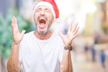 Orta yaş ağarmış komuta sizde Noel şapka üzerinde arka plan deli izole ve deli bağırarak ve agresif ifade ve silah kaldırdı bağırıyor. Hayal kırıklığı kavramı.