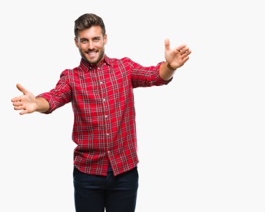 Yakışıklı delikanlı sarılmak için kollarını açarak gülümseyerek kameraya bakarak izole arka plan üzerinde. Neşeli ifade kucaklayan mutluluk.