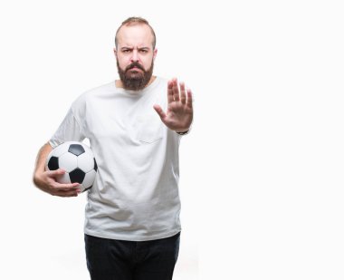 Açık eliyle dur işareti ile ciddi ve kendine güvenen ifade, savunma jest yapıyor izole arka plan üzerinde futbol futbol topu tutan genç beyaz hipster adam