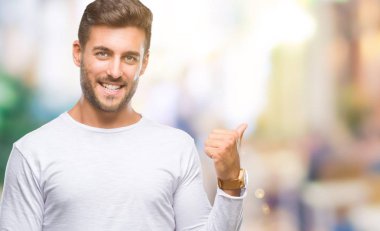 Yakışıklı delikanlı arıyor ve başparmak yanında yukarıyı mutlu yüz ile gülümseyen izole arka plan üzerinde.