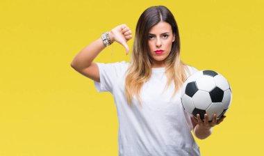 Kızgın yüz, eksi işareti aşağı antipati başparmak ile gösterilen, ret kavramı ile izole arka plan üzerinde futbol topu tutan genç güzel kadın