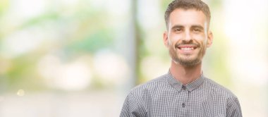 Genç hipster adam yüzünde mutlu ve güzel bir gülümseme ile. Şanslı kişi.