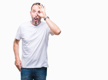 Sürpriz yüz, göz parmaklarının arasından seyir ile ok jest yapıyor izole arka plan üzerinde beyaz t-shirt giyen orta yaş ağarmış komuta sizde şok. İmansız ifade.