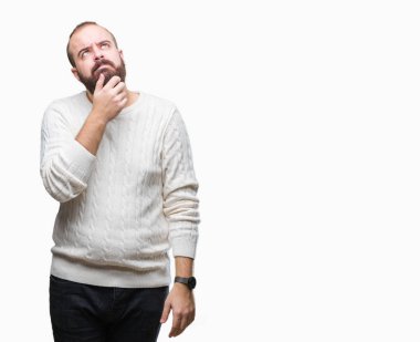 Üzerinde kış kazak giyen genç beyaz hipster adam arka plan çene düşünme hakkında soru, dalgın ifade üzerine el ile izole. Düşünceli yüzüyle gülümsüyor. Şüphe kavramı.