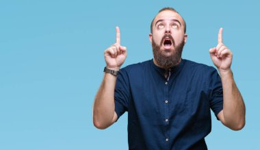 Genç beyaz hipster adam izole arka plan üzerinden hayran ve yukarıya bakıp parmakları ile işaret şaşırttı ve silah kaldırdı.