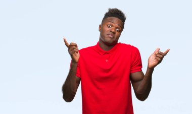 Afrikalı-Amerikalı genç izole arka plan clueless ve şaşkın bir ifadeyle kollar ve eller ortaya çıkar üzerinden. Şüphe kavramı.