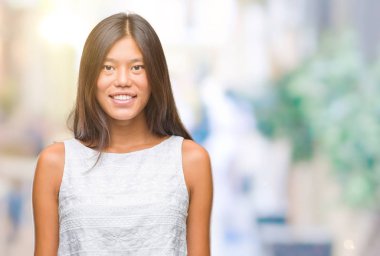 Genç Asyalı kadın yüzünde mutlu ve güzel bir gülümseme ile izole arka plan üzerinde. Şanslı kişi.