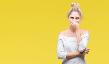 Bir şey pis ve iğrenç kokulu izole arka plan, dayanılmaz koku, holding nefes burun parmaklar ile genç güzel sarışın ve mavi gözlü kadın. Kötü kokuyor kavramı.