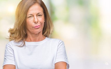 Orta yaş üst düzey İspanyol kadın izole arka plan şüpheci ve çapraz kolları olan yüzündeki gergin, onaylamayan ifade yüzünden. Negatif kişi.