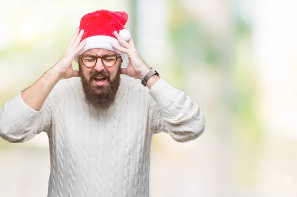 必死と強調した頭痛に苦しんで孤立の背景の上身に着けているクリスマスの帽子とメガネの若い白人男の痛みと片頭痛 頭に手 — ストック写真