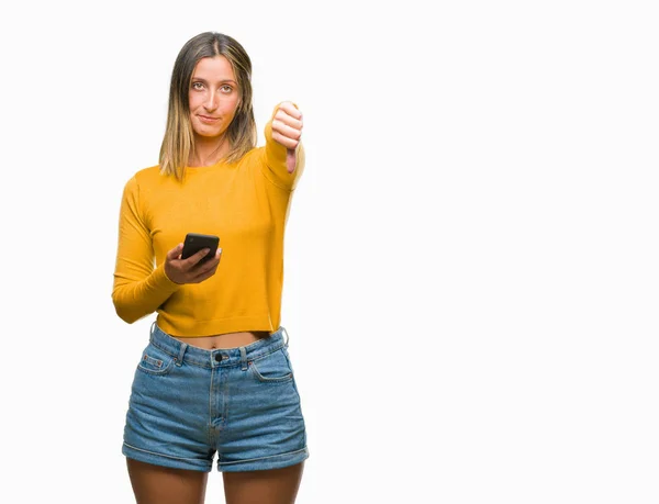 年轻美丽的女人发送消息使用智能手机在孤立的背景与愤怒的脸 否定的符号显示不喜欢拇指向下 拒绝概念 — 图库照片