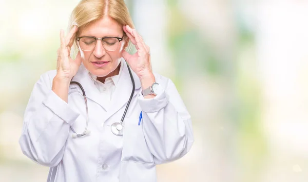 Middle age blonde doctor woman over isolated background with hand on head for pain in head because stress. Suffering migraine.