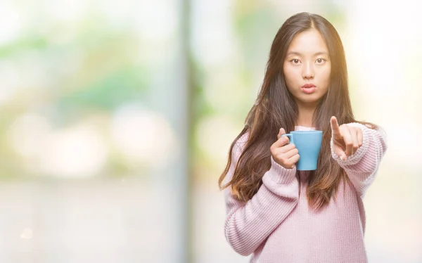 Joven Asiática Bebiendo Café Sobre Fondo Aislado Señalando Con Dedo —  Fotos de Stock