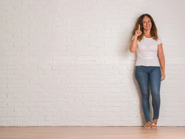 Midden Leeftijd Latino Vrouw Witte Bakstenen Muur Verrast Met Een — Stockfoto