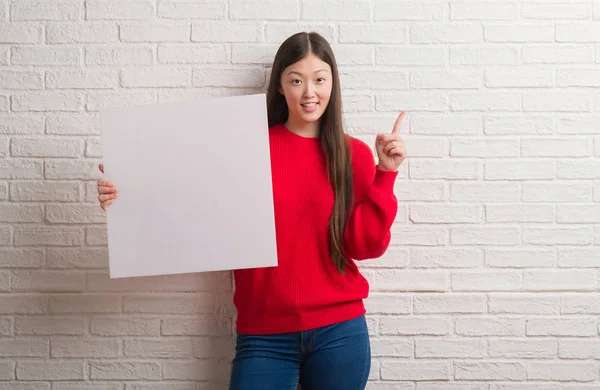 Jonge Chinese Vrouw Bakstenen Muur Bedrijf Banner Verrast Met Een — Stockfoto