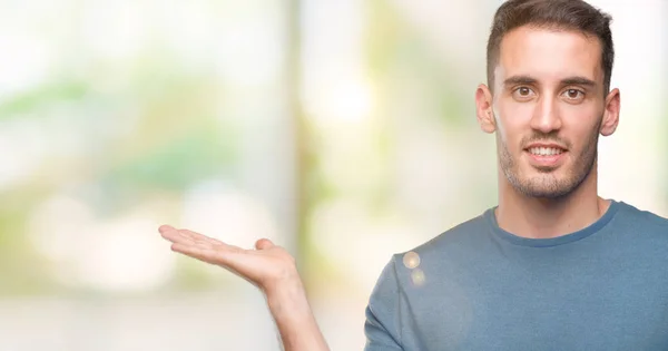 Bonito Jovem Casual Homem Sorrindo Alegre Apresentando Apontando Com Palma — Fotografia de Stock