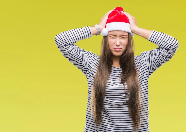 Young beautiful caucasian woman wearing christmas hat over isolated background suffering from headache desperate and stressed because pain and migraine. Hands on head.