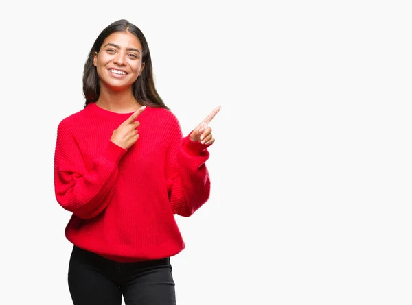 分離背景笑顔で側に つの手と指で指しているカメラ目線の上冬のセーターを着た若い美しいアラブ女性 — ストック写真