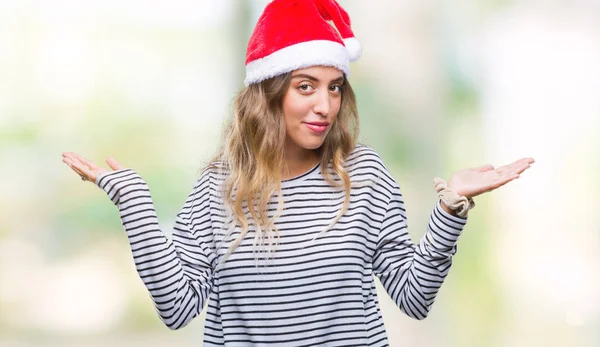 上クリスマス帽子身に着けている美しい若いブロンドの女性は 腕と手を上げて背景無知と混乱式を分離しました 疑いのコンセプト — ストック写真