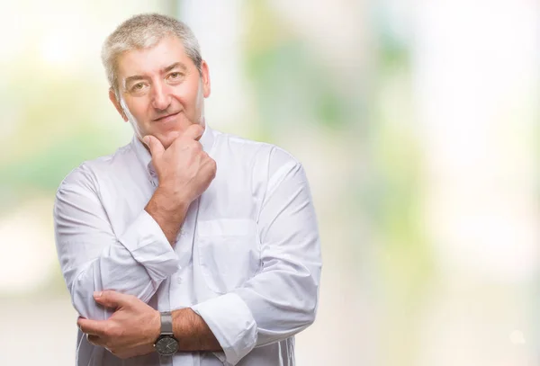 Handsome senior man over isolated background looking confident at the camera with smile with crossed arms and hand raised on chin. Thinking positive.