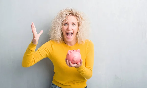 Jonge Blonde Vrouw Grunge Achtergrond Piggy Bank Holding Erg Blij — Stockfoto