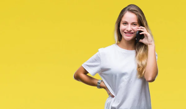 年轻美丽的金发女子打电话使用智能手机在孤立的背景与一个愉快的脸站立和微笑与自信的微笑显示牙齿 — 图库照片