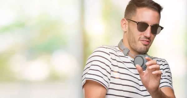 Schöner Junger Mann Mit Kopfhörern Angewiderten Gesichtsausdruck Ungehalten Und Ängstlich — Stockfoto