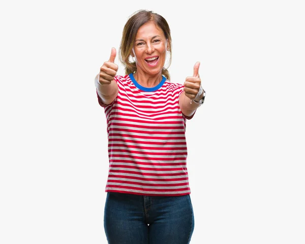 中年资深西班牙裔妇女在孤立的背景批准做积极手势与手 竖起大拇指微笑 并为成功而高兴 看着相机 胜利者的手势 — 图库照片