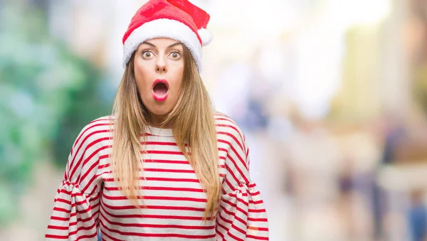 驚きの表現 恐怖と興奮した顔でショックを受けて孤立した背景にクリスマスの帽子をかぶって若い美しい女性 — ストック写真