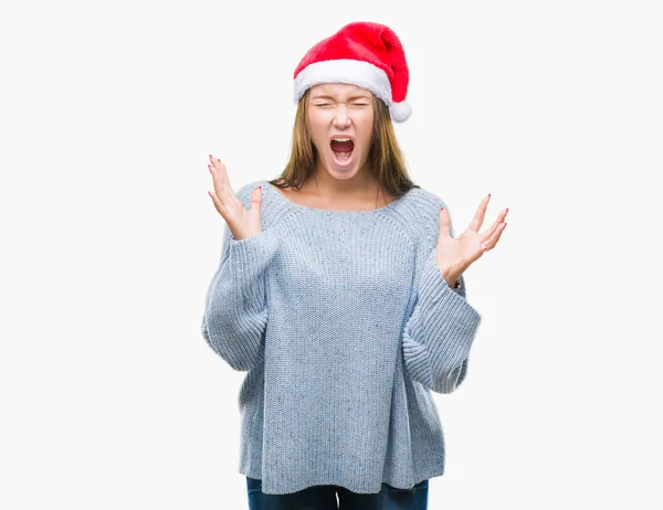 年轻美丽的白人妇女戴着圣诞节帽子在孤立的背景疯狂和疯狂的呼喊和咆哮与积极的表达和武器提出 挫折概念 — 图库照片