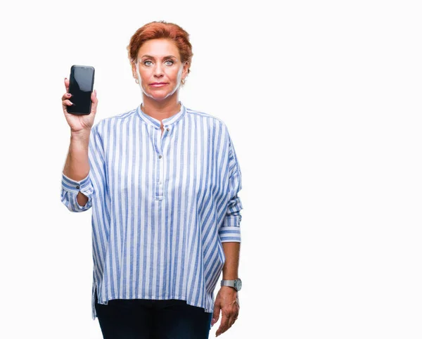 Attraktive Ältere Kaukasische Rothaarige Frau Zeigt Smartphone Bildschirm Über Isoliertem — Stockfoto