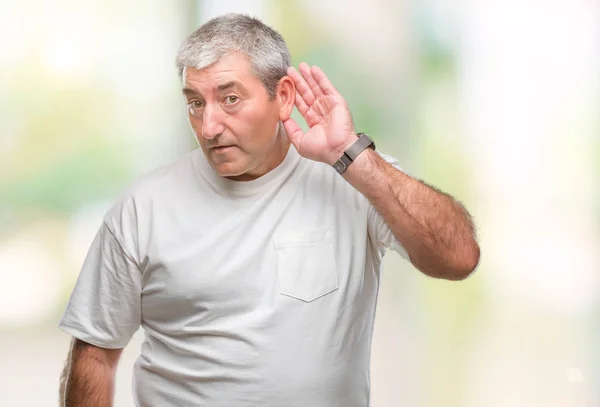噂やゴシップに審理をリスニングの耳に手を浮かべて隔離された背景にハンサムな年配の男性 難聴の概念 — ストック写真