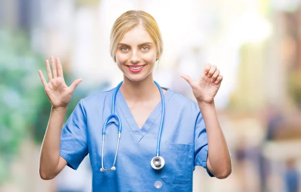 年轻美丽的金发医生外科医生护士妇女在孤立的背景显示和指向用手指数字六 同时微笑着自信和快乐 — 图库照片