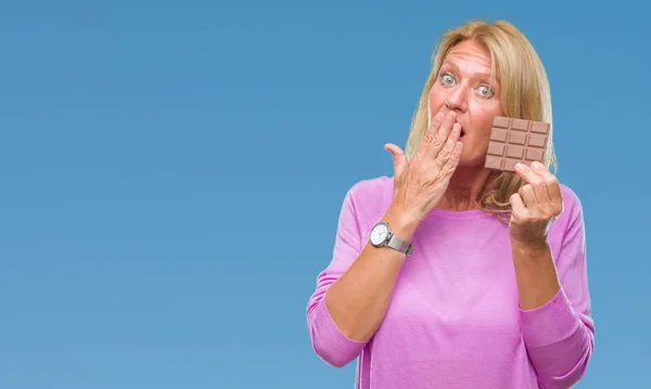 Šokovala Blond Žena Středního Věku Jíst Čokolády Izolované Pozadí Kryt — Stock fotografie