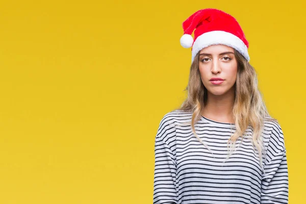美しい若い金髪女性の顔に真剣な表情で孤立した背景にクリスマス帽子をかぶっています シンプルで自然なカメラを見てください — ストック写真
