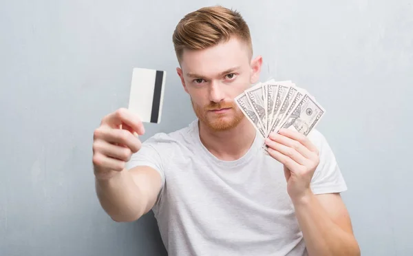 Fiatal Vöröshajú Ember Tartja Dollár Bankkártya Komoly Kifejezés Arcán Egyszerű — Stock Fotó