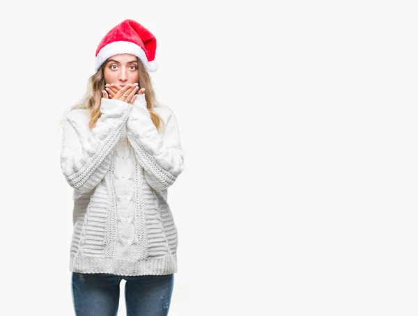 美しい若い金髪女性の孤立した背景のミスのための手で口を覆っているショックを受けた上クリスマス帽子をかぶっています 秘密の概念 — ストック写真