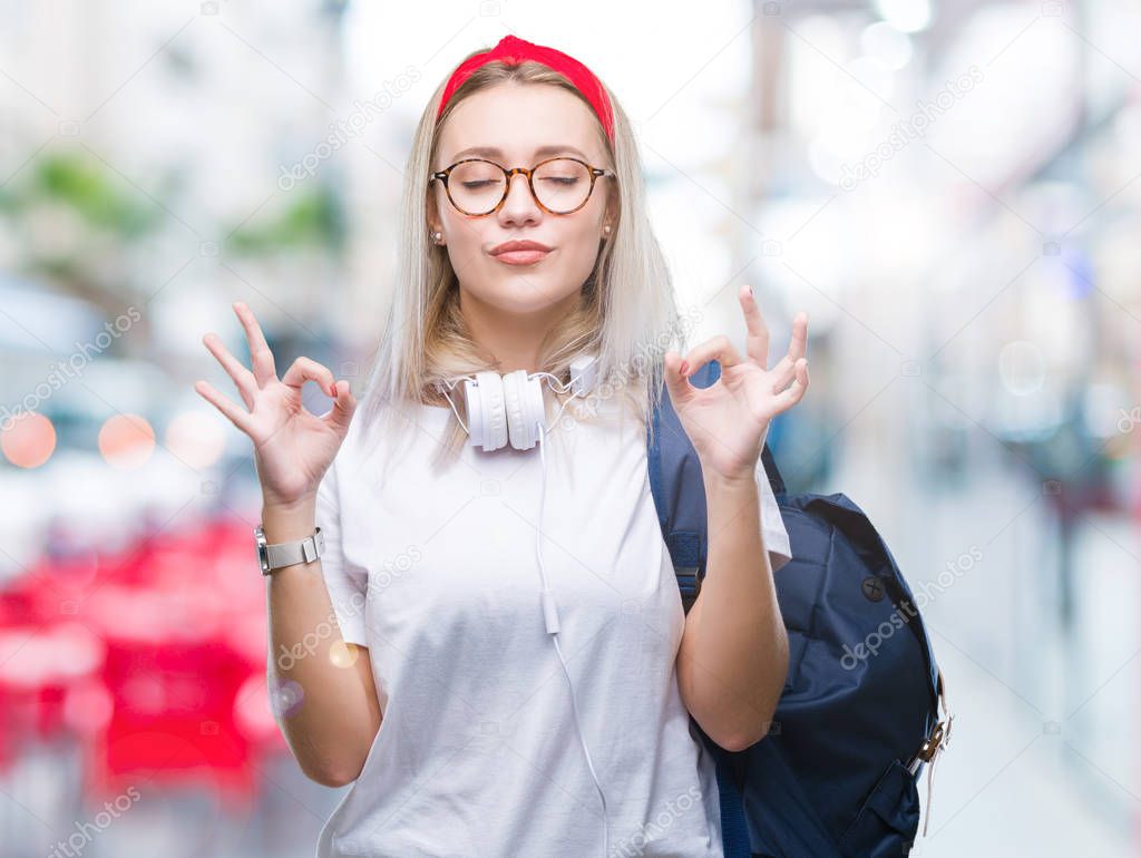 Young blonde student woman wearing glasses and backpack over isolated background relax and smiling with eyes closed doing meditation gesture with fingers. Yoga concept.