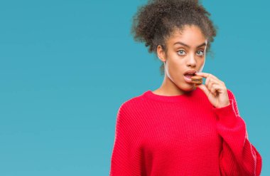 Genç afro Amerikalı kadın çikolata macaron acımak yüz ciddi düşünüyorum üstünde kendine güvenen bir ifade ile izole arka plan üzerinde yemek