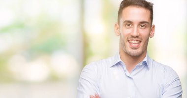 Yakışıklı genç işadamı mutlu yüz ile gülümseyerek kameraya seyir silah geçti. Olumlu bir kişi.