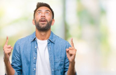 İzole arka plan yetişkin İspanyol adam hayret ve yukarıya bakıp parmakları ile işaret şaşırttı ve silah kaldırdı.