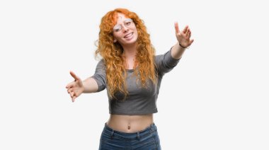 Sarılmak için kollarını açarak gülümseyerek kameraya arayan genç Kızıl saçlı kadın. Neşeli ifade kucaklayan mutluluk.