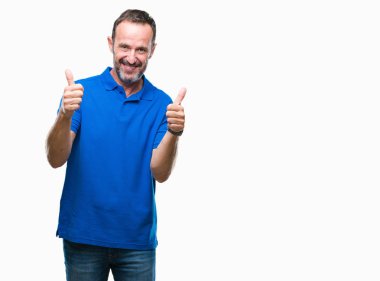 Orta yaş ağarmış komuta sizde izole arka plan başarı işareti el ile pozitif jest yapıyor üzerinde başparmak gülümseyen ve mutlu. Neşeli bir ifadeyle, kazanan jest kameraya bakıyor.