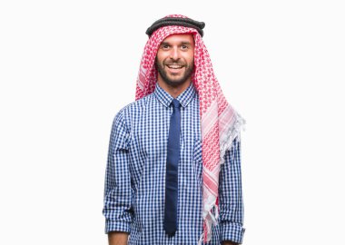 Keffiyeh yüzünde mutlu ve güzel bir gülümseme ile izole arka plan üzerinde giyen genç yakışıklı Arap iş adam. Şanslı kişi.
